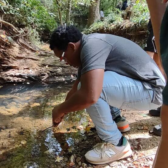 boy taking water samples in stream